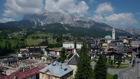 Tiefflug-über-Das-Wohngebiet-Von-Cortina-Und-Die-Dolomiten-Im-Hintergrund,-Italien