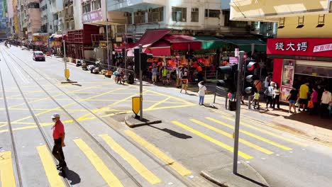 Pedestrians-Crossing-The-Road-in-Sheung-Wan,-Hong-Kong,-in-the-Early-Morning
