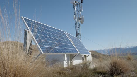 Solar-panel-and-transmission-tower-on-NZ-mountain-with-dry-tussock-grass