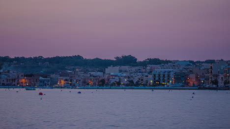 Shot-of-waterfront-city-buildings-in-Gzira,-Il-Gzira,-Malta-as-sun-rays-lighting-up-the-morning-sky-in-timelapse