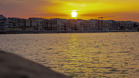Timelapse-shot-of-sun-rising-over-condo-hotels-in-Gzira,-Il-Gzira,-Malta-during-morning-time