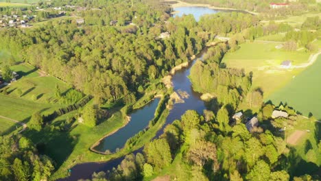 Vibrant-landscape-of-lakes,-forest-and-villages-in-Latvia,-aerial-drone-view