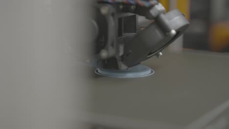 Detail-shot-to-3D-printer-which-is-at-the-beginning-of-printing-blue-sprocket-in-white-laboratory
