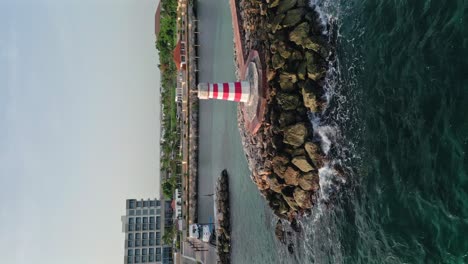 Vertical-view-Of-lighthouse-in-front-of-Marina-Hilton-Garden-Inn-hotel-on-the-Caribbean-sea-In-La-Romana,-Dominican-Republic