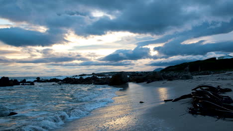 Stimmungsvoller-Sonnenuntergangshimmel-Mit-Gewitterwolken,-Blick-Auf-Wellen,-Die-Auf-Den-Strand-Hinauslaufen