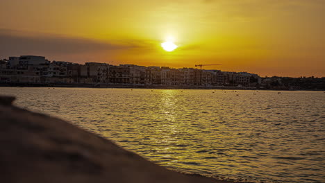 Timelapse-shot-of-sun-rising-over-condo-hotels-in-Gzira,-Il-Gzira,-Malta-during-morning-time