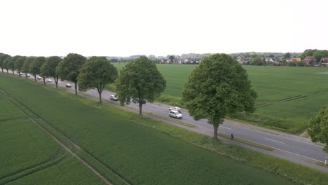 Aerial-shot-of-vehicles-driving-through-fields-ready-for-harvesting-in-Germany