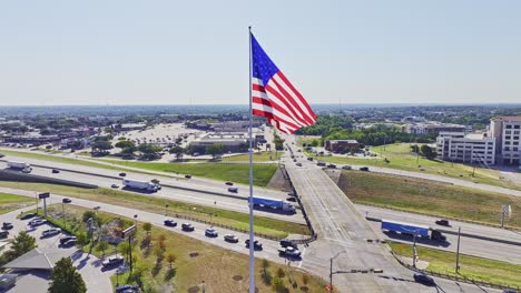 Große-Amerikanische-Flagge-Mit-Der-Interstate-30-Im-Hintergrund