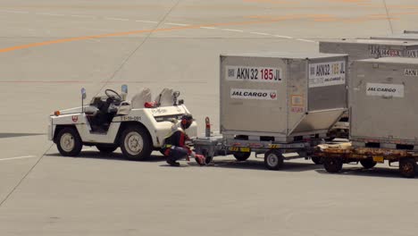 Japan-Airlines-crew-staff-truck-driver-in-airport-taking-sticking-wagons-inside-Landing-track-Okinawa-International-Airport-train