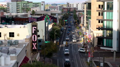 A-4k-aerial-drone-shot-slowly-moving-backwards-on-a-downtown-street-in-Tucson,-AZ-revealing-local-stores-and-the-famous-Fox-Theater