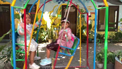 Indonesien---30.-Juli-2023:-Zwei-Kleine-Asiatische-Mädchen-Spielen-Auf-Schaukeln-Im-Park
