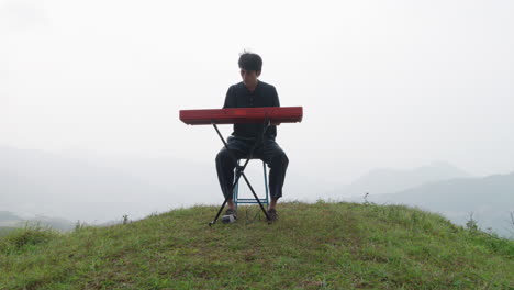 Young-musician-playing-his-keyboard-player-outdoors