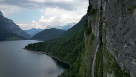 Wunderschöner-Wasserfall,-Der-Aus-Felsigen-Alpen-Mit-Der-Kulisse-Des-Klontalersees-Stürzt
