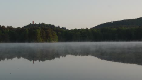 Kalter-Sommermorgen-Im-Wald-Mit-Nebel,-Der-über-Die-Seeoberfläche-Zieht