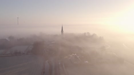 Wide-shot-of-rural-town-of-cornwerd-friesland-with-low-morning-fog,-aerial