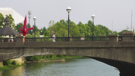 Erwachsener-Mann-Läuft-Tagsüber-An-Der-Fußgängerbrücke-über-Den-White-River-In-Indianapolis-In-Indiana,-Vereinigte-Staaten