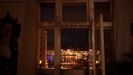 Street-view-through-windows-of-an-apartment-overlooking-Budapest-Street-at-night,-Jaszai-Mari-Square,-Hungary