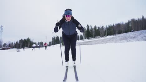 Slow-motion-tilt-up-shot-from-moving-skiis-in-snow-to-female-athlete-reveal