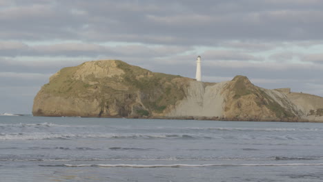 Wide-shot-of-New-Zealand's-rock-formation-and-lighthouse-at-Castle-Point-Beach