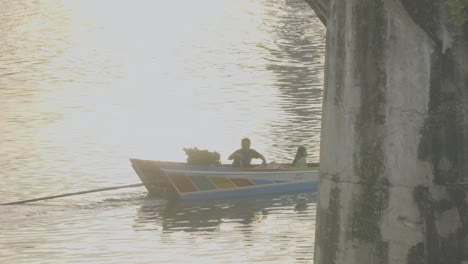 Eine-Gruppe-Von-Touristen,-Die-Von-Einer-Abenteuerlichen-Sonnenuntergangsfahrt-Auf-Einem-Longtail-flussboot-Den-Khwae-Fluss-Hinauf-Zurückkehren-Und-Unter-Der-Berühmten-Kwai-flussbrücke-In-Kanchanaburi,-Thailand,-Hindurchfahren
