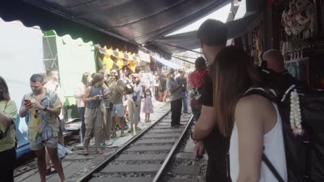Eine-Menge-Touristen-Warten-Auf-Die-Ankunft-Des-Berühmten-Zuges,-Der-Durch-Den-Mae-Klong-Markt-Oder-Regenschirmmarkt-In-Samut-Songkhram,-Thailand,-Fährt