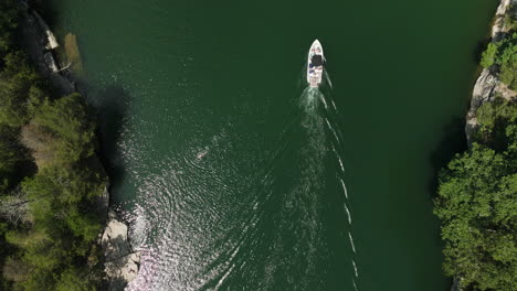 Mesmerizing-aerial-topdown-above-Beaver-Lake,-boat-passing-slowly