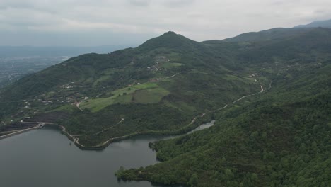 Vista-Aérea-De-La-Hermosa-Naturaleza-De-Los-Balcanes,-Colinas-Y-Montañas-Con-Bosque-Al-Lado-Del-Lago,-El-Paisaje-Natural-Bajo-Un-Cielo-Nublado