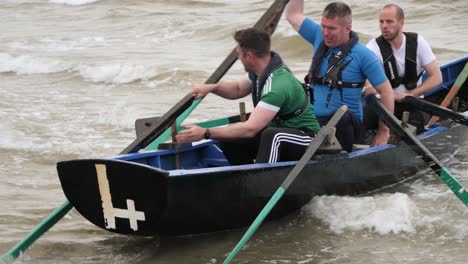 Crew-attempts-to-push-off-currach-into-open-ocean-waters-to-race