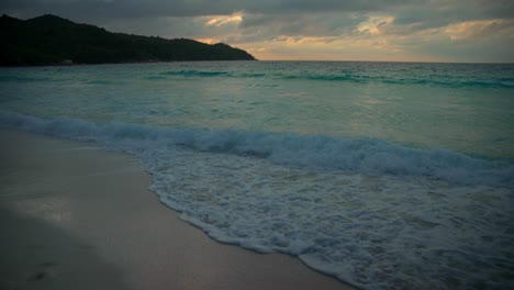 Beach-in-Seychelles-filmed-at-twin-light-after-sunset-with-a-beautiful-ocean-and-mountains-in-the-views