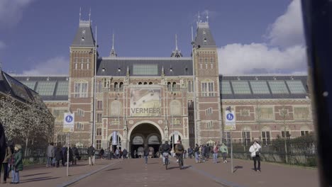 Vibrant-Amsterdam:-Tourists-and-cyclists-at-the-iconic-Rijksmuseum-under-a-serene-blue-sky