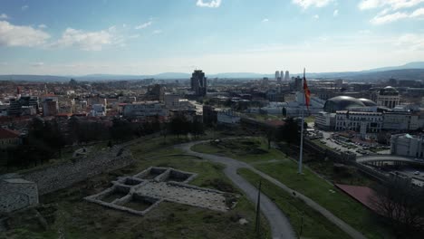 The-old-fortress-of-Skopje-in-Macedonia,-wawing-national-flag,-castle-and-new-houses-with-streets,-squares,-and-view