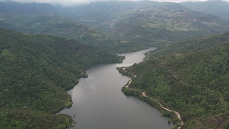 Vista-De-Drones-De-La-Naturaleza-En-Los-Balcanes,-Colinas-Y-Montañas-Con-Un-Bosque-Al-Lado-Del-Lago,-El-Paisaje-Natural-Bajo-Un-Cielo-Nublado