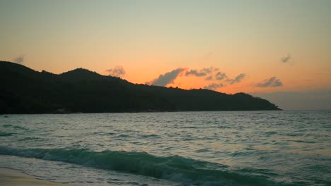 Wunderschöner-Strand-Auf-Den-Seychellen-Bei-Sonnenuntergang-Mit-Dem-Meer-Und-Den-Bergen-Im-Blick
