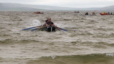Team-of-paddlers-row-currach-boats-out-into-open-ocean-for-exhibition-races