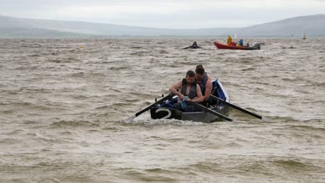 Männer-Trocknen-Ruder-Und-Paddel-Eines-Currach-Bootes-Im-Offenen-Wasser-Und-Bereiten-Sich-Auf-Das-Rennen-Vor