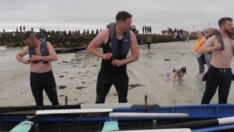 Muscular-irish-men-prepare-and-warm-up-for-currach-boat-racing-on-grey-gloomy-day