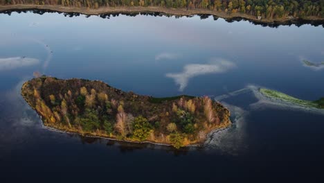 A-drone-rotates-high-above-an-island-in-a-lake-at-Kalmthoutse-Heide-Antwerp,-Belgium