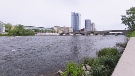Slow-motion-shot-of-the-Grand-river-flowing-through-downtown-Grand-Rapids,-Michigan