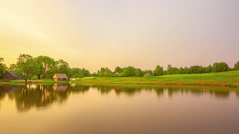 Golden-green-blue-purple-cotton-candy-skies-change-above-idyllic-farm-home-and-pond