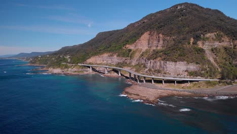 Luftaufnahme-Der-Sea-Cliff-Bridge,-Sonniger-Tag,-Grand-Pacific-Drive,-New-South-Wales,-Australien---Rückwärtige-Drohnenaufnahme
