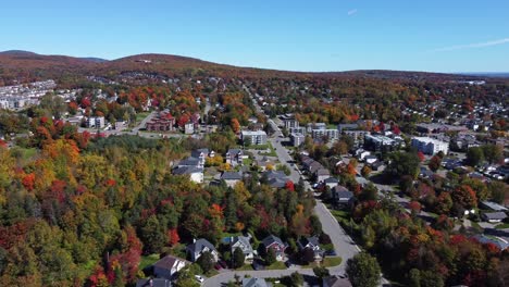Erleben-Sie-Die-Atemberaubende-Schönheit-Des-Herbstlaubs-Von-Quebec-Aus-Einer-Einzigartigen-Perspektive,-Während-Eine-Drohne-über-Ein-Bezauberndes-Viertel-Inmitten-Eines-Ruhigen-Waldes-Fliegt
