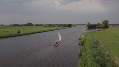 Traditional-sailing-boat-moving-on-water-through-wind-at-Netherlands,-aerial