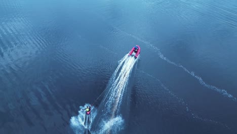 Kneeboarder-cutting-out-behind-speed-boat-High-angle-Aerial