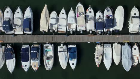 Aerial-overhead-pan-of-the-boats-moored-at-the-marina-at-Capodimonte-on-Lake-Bolsena,-Province-of-Viterbo,-Italy