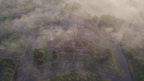 Aerial-shot-of-famous-fortress-bourtange-covered-with-small-layer-of-fog-during-sunrise,-aerial