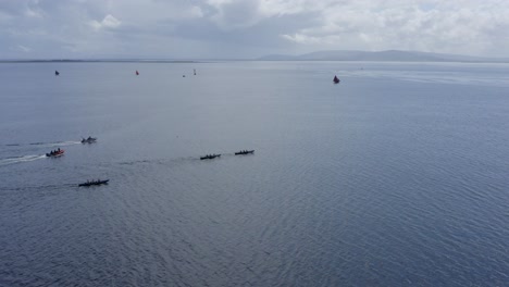 Drone-orbits-around-currach-rowing-boats-quickly-moving-in-open-ocean