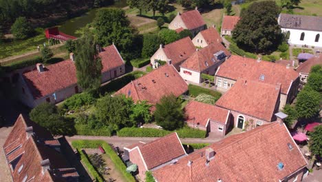 Reveal-shot-of-houses-with-orange-roofs-at-Fort-Bourtange,-aerial
