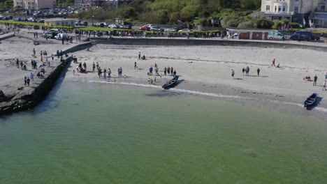 Drohne-Zieht-Sich-Von-Currach-Boot-Zurück,-Das-Auf-Dem-Offenen-Meer-Gestrandet-Ist,-Während-Die-Feierlichkeiten-In-Galway,-Irland,-Weitergehen