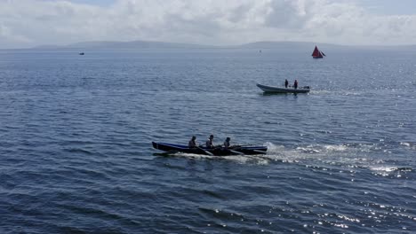 Side-view-tracking-of-currach-boats-and-galway-hooker-ships-in-open-atlantic-ocean,-ireland