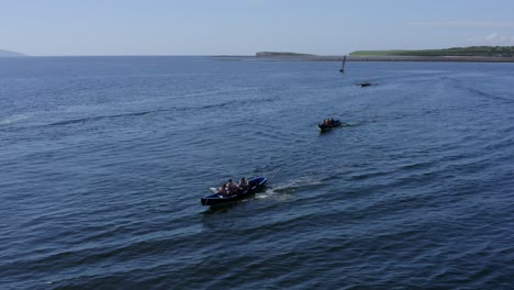 Aerial-drone-orbits-around-currach-rowing-through-galway-coastal-waters